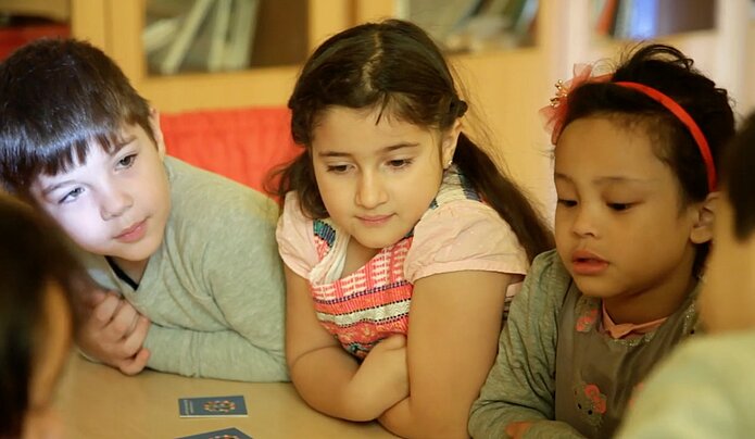 Kinder sitzen während eines Kurses zur Sprachförderung zusammen