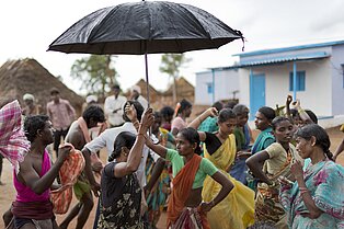 Indische Frauen tanzen im Regen